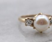 Simple and classic, this classic pearl ring has a beautifully polished 14-karat yellow gold band, and two small accent diamonds set on each side of the pearl. The band has a simple and fluid design, and the creamy white cultured pearl makes the perfect understated piece.nnMetal: 14K Yellow GoldnGem: PearlnGem Measurements: 7.6 mm, roundnAccents: 2 Diamonds totaling 0.43 Carats, SI2 in clarity, G in colornRing Size: 6.75nMarks: